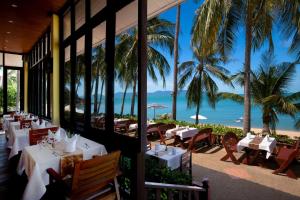 a restaurant with a view of the beach and palm trees at Pinnacle Samui Resort in Mae Nam