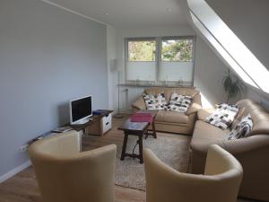 a living room with two couches and a tv at Hus-Annett-Lüchttoorm in Tating