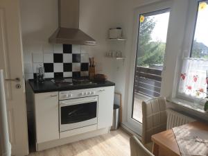 a kitchen with a white stove top oven next to a window at Hus-Annett-Lüchttoorm in Tating