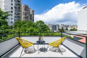 balkon z 2 krzesłami i stołem na dachu w obiekcie Boutique Hotel MOJO w mieście Tbilisi City