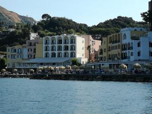 un grupo de edificios junto a una masa de agua en Villetta Baia San Montano en Ischia