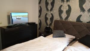 a bedroom with a bed and a flat screen tv at Dorfkrug Grabau 23845 in Grabau