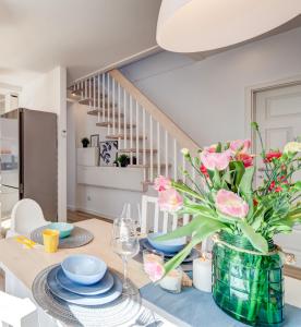 une salle à manger avec une table et un vase de fleurs dans l'établissement HM-Family-Apartment by Eve, à Świnoujście