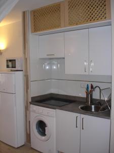 a kitchen with a washing machine and a sink at Legacy Apartments in Salou