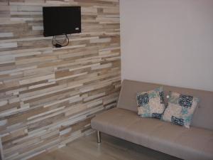 a living room with a couch and a tv on a wall at Legacy Apartments in Salou