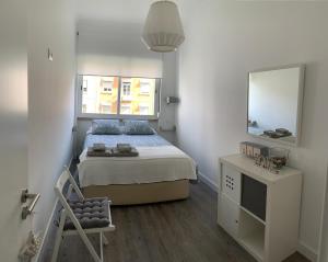 a bedroom with a bed and a mirror and a chair at Starhouse in Lisbon