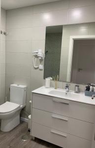 a bathroom with a toilet and a sink and a mirror at Starhouse in Lisbon