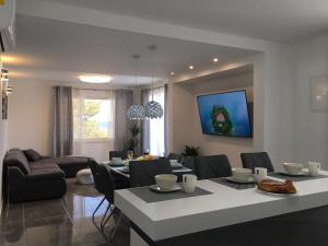 Apartments Sunny Hvar - with pool; في Basina: غرفة طعام وغرفة معيشة مع طاولة وكراسي