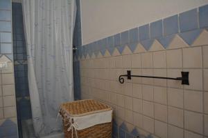 - Baño con cortina de ducha y cesta en Casa della Vespa, en Orosei