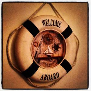 Al Porto Di Roma B&B في ليدو دي أوستيا: شارة لوحة ترحيب مع ساعة وقارب