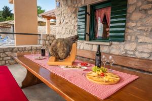 een tafel met een berenbeeld en wijnglazen bij Villa Danica in Vid