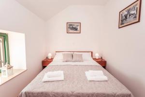 een slaapkamer met een groot bed en 2 witte handdoeken bij Villa Danica in Vid +41 foto's