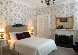 una camera da letto con un grande letto e carta da parati floreale di Balmoral House Bed & Breakfast a St. John's