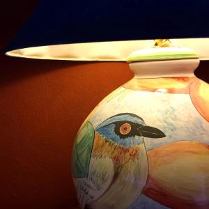 a lamp with a bird painted on the side of a vase at Lucky Bug Bed And Breakfast in Nuevo Arenal