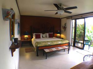 1 dormitorio con 1 cama y ventilador de techo en Lucky Bug Bed And Breakfast en Nuevo Arenal