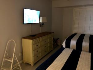 a bedroom with a bed and a television on a dresser at Ocean Walk Resort 508 in Daytona Beach