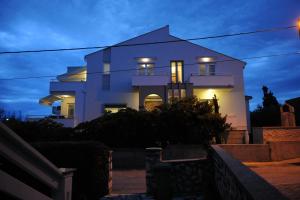 诺瓦利娅Rooms Villa Ropuš的一间白色的房子,晚上有灯