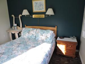 a bedroom with a bed and a lamp at Auld Farm Inn B&B in Baddeck