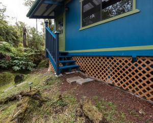 una casa blu con una veranda blu e una finestra di Honu Hale a Volcano