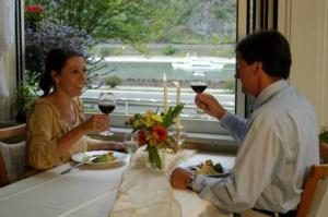 Ein Mann und eine Frau, die an einem Tisch mit Gläsern Wein sitzen in der Unterkunft Perle am Rhein in Boppard