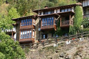 una casa en la parte superior de una pared de roca en APARTAMENTOS LA COTERA - Barrio de CAMBARCO en Cambarco