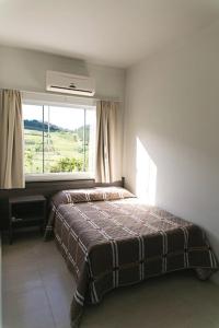 a bedroom with a bed and a large window at Hotel Bergozza in Rio do Sul +67 photos