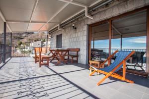 a patio with chairs and a hammock on a house at Villa Vistamar Lapcici in Budva