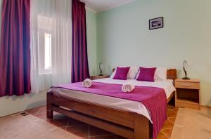 a bedroom with a large bed with purple curtains at Villa Vistamar Lapcici in Budva +19 photos