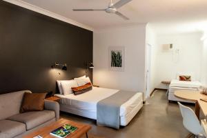 a hotel room with a bed and a couch at Motel Nomad in Cairns