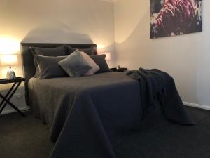 a bedroom with a bed with a blue blanket on it at Rosewood Cottage in Grattai