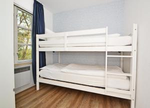 バンシンにあるFerienanlage Bansin Seepferdchen 3の窓付きの客室の白い二段ベッド1台分です。