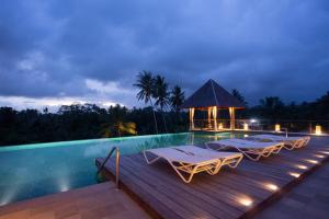 a swimming pool with lounge chairs and a gazebo at Tejaprana Bisma - CHSE Certified in Ubud