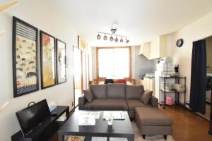 a living room with a couch and a table at Condominio Mozu 102 in Sakai