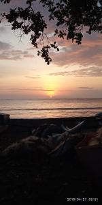 - un coucher de soleil sur la plage avec l'océan en arrière-plan dans l'établissement NAYYLA Homestay, à Pangandaran