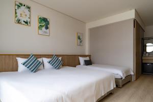 2 Betten nebeneinander in einem Zimmer in der Unterkunft Feng-Chi Inn in Taitung