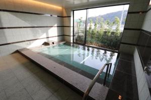 館山的住宿－Yado Hanasaku，一座带大窗户的建筑中的游泳池