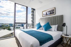 a hotel room with a large bed and a large window at Brisbane One Apartments in Brisbane