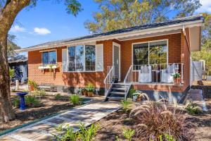 a brick house with windows and a porch at 'In The Vines' Guest Cottage, Barossa Valley in Lights Pass