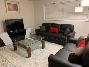 a living room with a black couch and a tv at The Palace at Kingston East in Rexburg