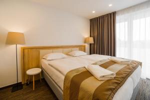 a hotel room with a large bed and a window at Apartment Dolfi, Senec in Senec