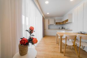 a kitchen and dining room with a table and flowers at Apartment Dolfi, Senec in Senec