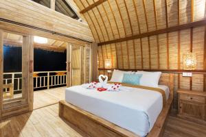 a bedroom with a large white bed in a room at The Dewi Premier in Nusa Penida