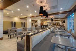 a restaurant with tables and chairs and a bar at Best Western Premier Airport/Expo Center Hotel in Louisville