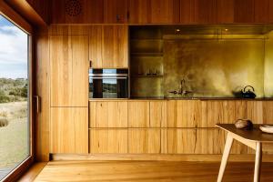 a kitchen with wood paneling and a large window at Seastacks at The Denison in Bicheno