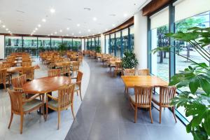 a restaurant with wooden tables and chairs and windows at Hanwha Resort Daecheon Paros in Boryeong