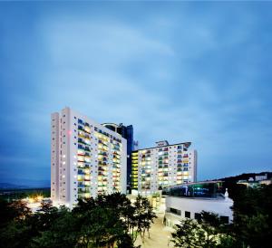 a tall building with lights on in a city at Hanwha Resort Daecheon Paros in Boryeong
