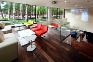 a living room with red and yellow chairs and tables at Hanwha Resort Daecheon Paros in Boryeong
