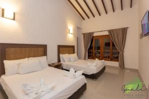 ein Schlafzimmer mit 2 Betten mit weißen Blumen darauf in der Unterkunft Finca Hotel Guali Santafe in Santa Fe de Antioquia