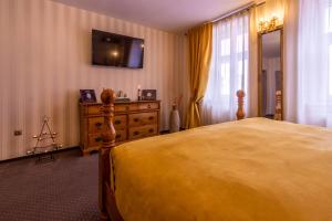 a bedroom with a large yellow bed and a dresser at Hermannstadt House 1 in Sibiu