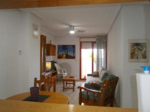 ein Wohnzimmer mit einem Sofa und einem Tisch in der Unterkunft Apartamento Frente Al Mar in Villajoyosa